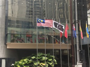 The Malaysian flag waving outside a public building.