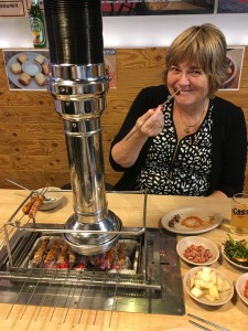 I am eating lamb. When they bring the lamb to your table, it's on metal skewers, but the meat is still raw. However, as you can see, there is a grill in the middle of the table. They bring out really hot coals and put them in the bottom of the grill.